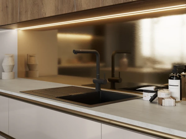 Modern kitchen with wooden cabinetry, gold backsplash, black sink and tap, concrete countertop, and under-cabinet lighting.